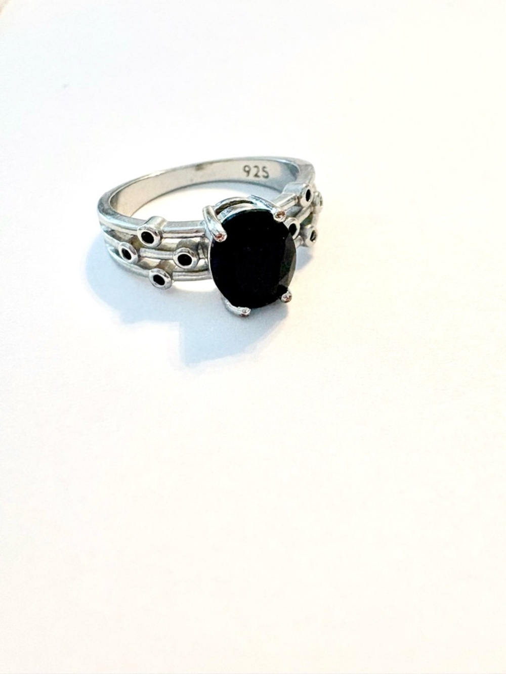 Black Spinel, 925 marked ring with 4 small stones on each side. Size 7 1/4